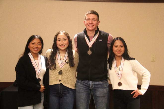 Perry High School and DMACC students Jennifer Ramos, Erika Guardado, Kain Killmer and Mia Munoz pose for a photo after receiving medals in the Perry Optimist Club essay contest.