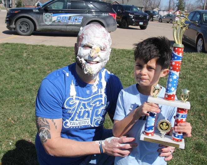 Alex Lott, with the Perry Police Department, poses for a photo with his son, Cain, during the Grand Finale of the Big Boom Bracket Battle on Monday, April 8, 2024.