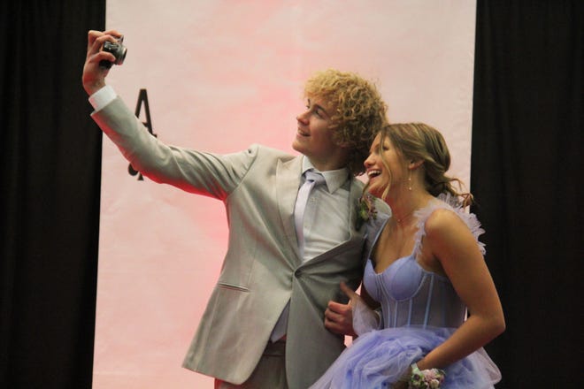 Nick Rees and Cela Hill take a selfie during the prom grand march on Friday, April 19, 2024, in the Woodward-Granger High School gym.