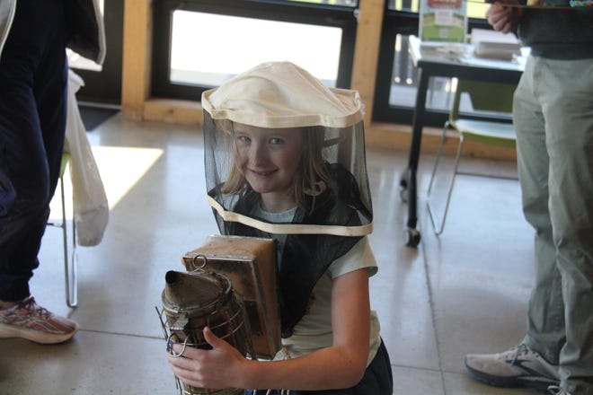 Ava Flagg, 8, of Johnston, poses for a photo at a beekeeping station during The Brenton Arboretum's Earth Day Celebration on Sunday, April 21, 2024, near Dallas Center.