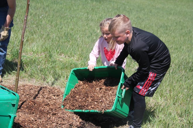 Emma, 5, and Henry, 9, Schuchmann, of Waukee, spread mulch around the base of a tree during The Brenton Arboretum's Earth Day Celebration on Sunday, April 21, 2024, near Dallas Center.