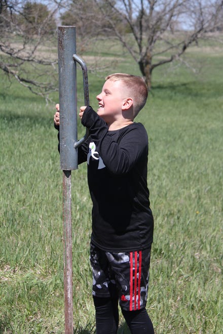 Henry Schuchmann, of Waukee, helps drive a stake into the ground during The Brenton Arboretum's Earth Day Celebration on Sunday, April 21, 2024, near Dallas Center.