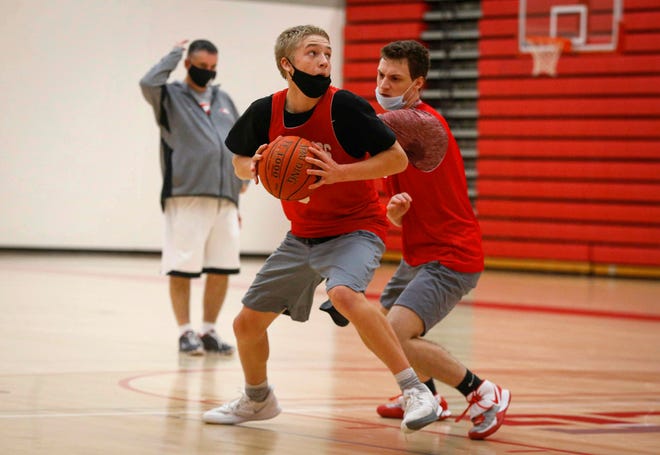 Dallas Center-Grimes head boys basketball coach Joel Rankin watches in the background as members of his top-ranked (Class 3A) Mustangs basketball team run a practice drill at Dallas Center-Grimes High School in Grimes on Wednesday, Jan. 7, 2021.
