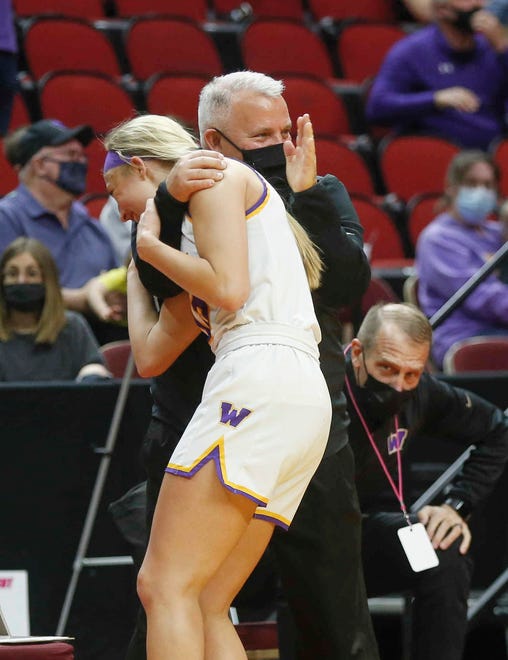 Waukee senior guard Katie Dinnebier is hugged by head coach Chris Guess late in the fourth quarter against Ankeny Centennial on Thursday, March 4, 2021, during the Iowa high school girls state basketball tournament at Wells Fargo Arena in Des Moines.